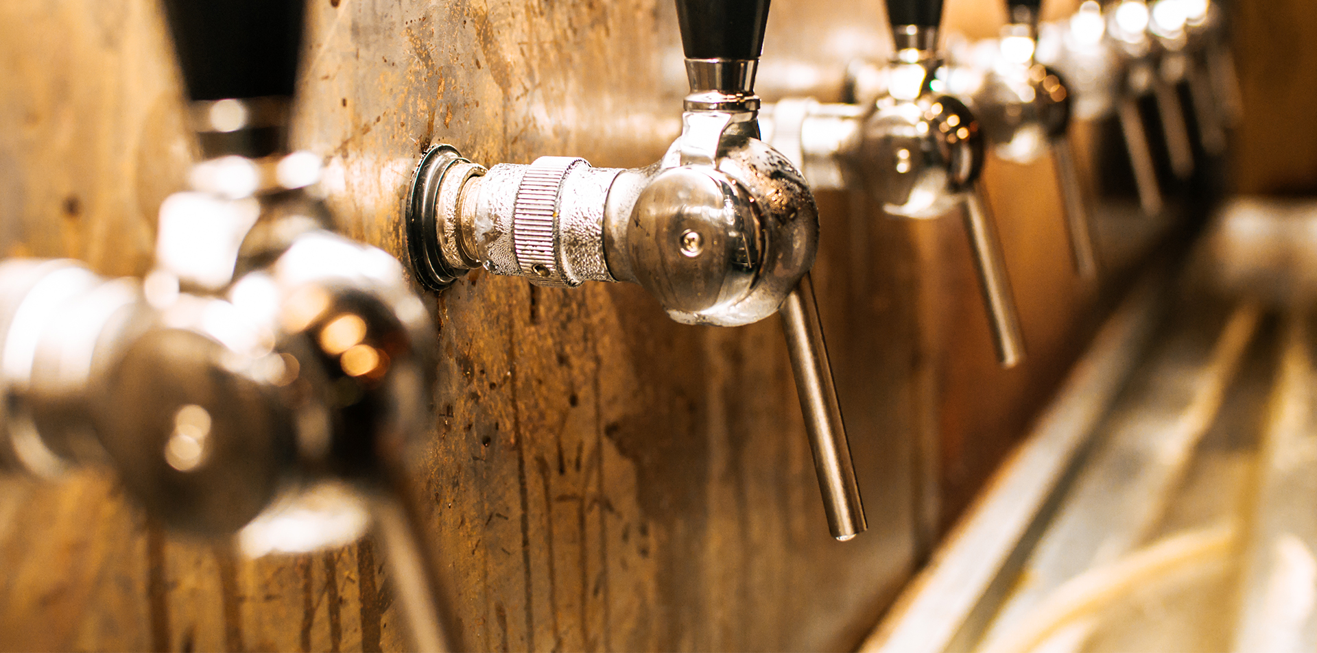 Many taps with a wooden background and black handle